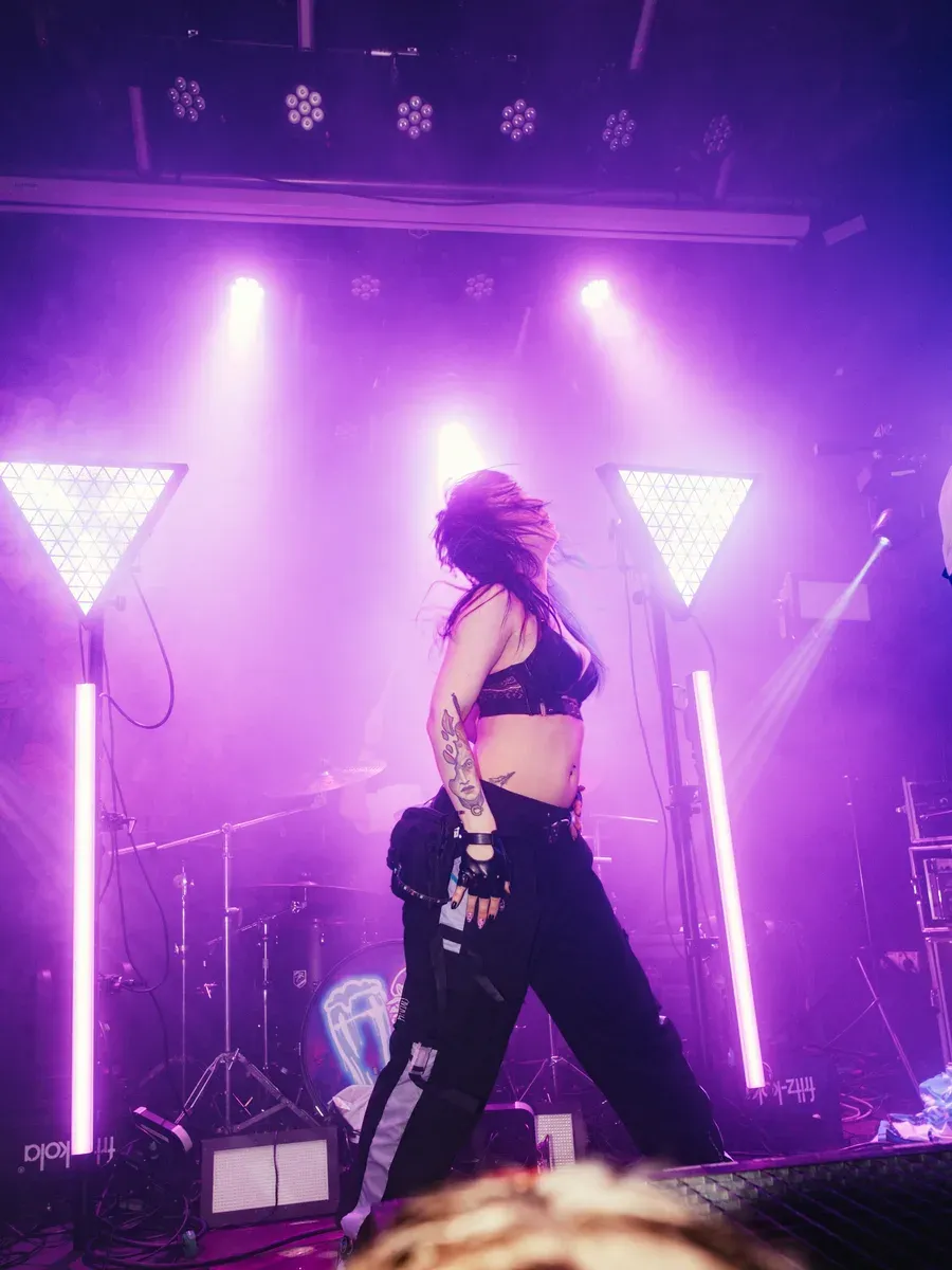 Taenzerin als Silhouette mit fliegenden Haaren im lila Licht