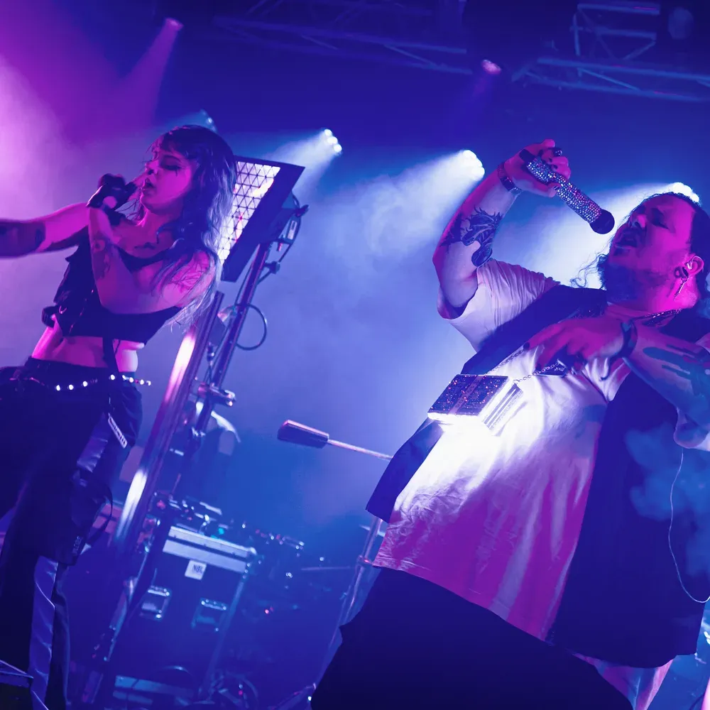 Taenzerin und Saenger performen zusammen im blauen Buehnenlicht