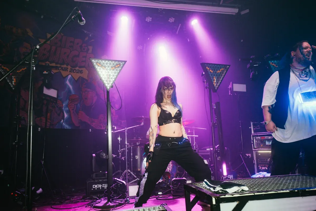 Taenzerin steht kraftvoll im pinken Buehnenlicht