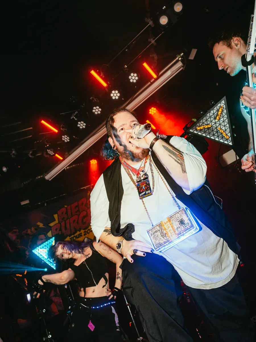 Saenger performt mit Rauch und rotem Buehnenlicht